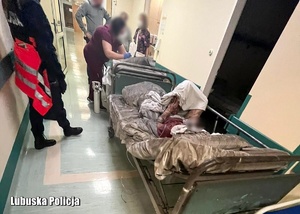 Szpitalny korytarz oraz łóżko, na którym leży ewakuowany pacjent.