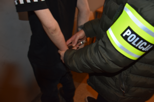 policjant zakłada kajdanki zatrzymanemu
